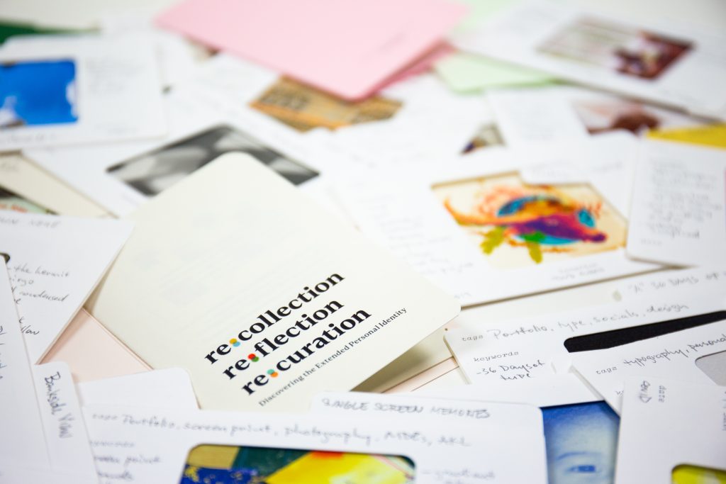 Photographs, notes and Memory Card Library materials spread across a work table